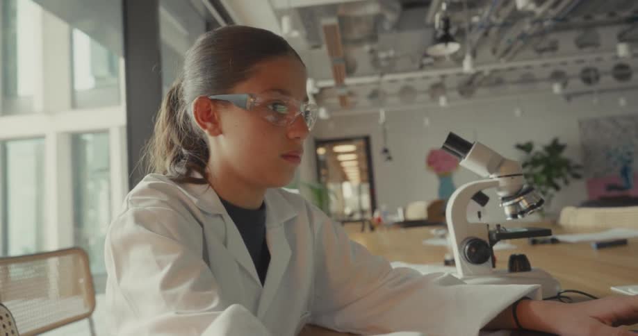 The girl is typing on a laptop in the lab