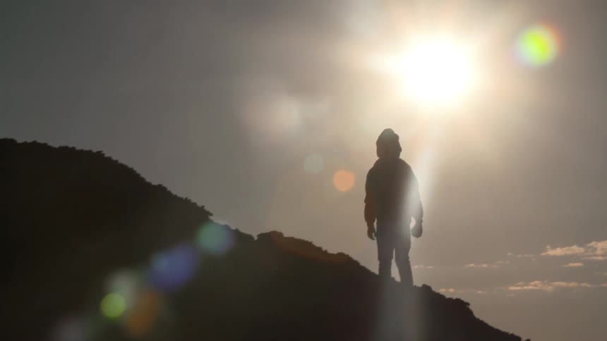 A person blocking the sunset