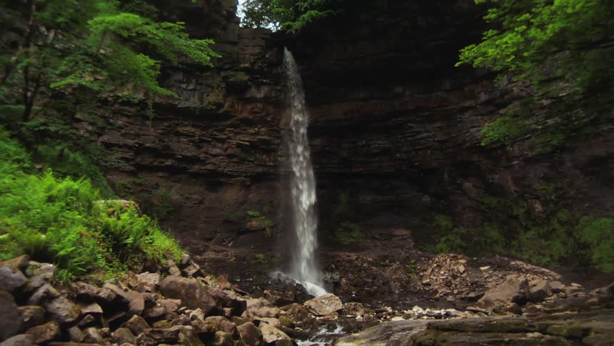 A waterfall pours off a cliff