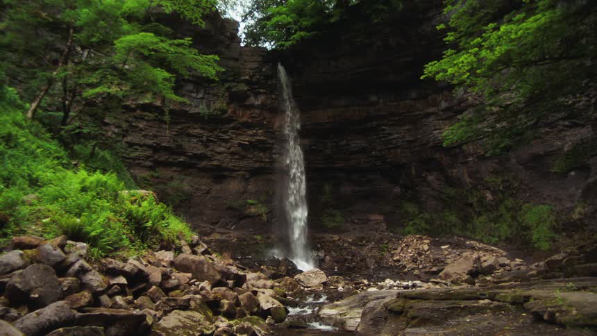 A small waterfall pours off the cliff