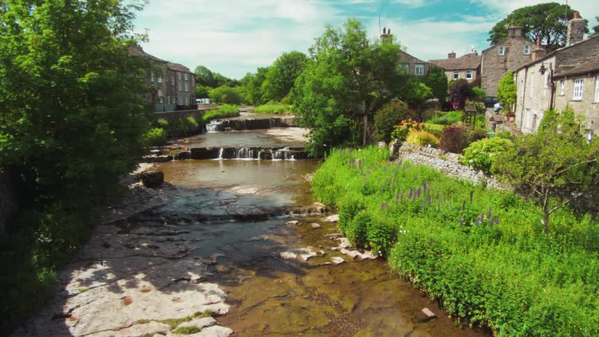 A creek runs between the homes