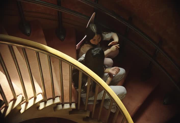 Two little girls sitting on a staircase talking