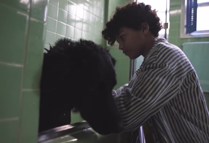 Boy bathing a dog in the bathtub