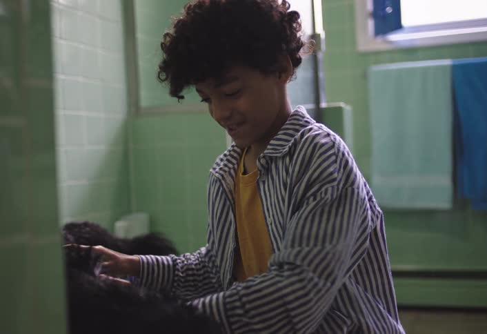 Boy bathing a blackhaired dog