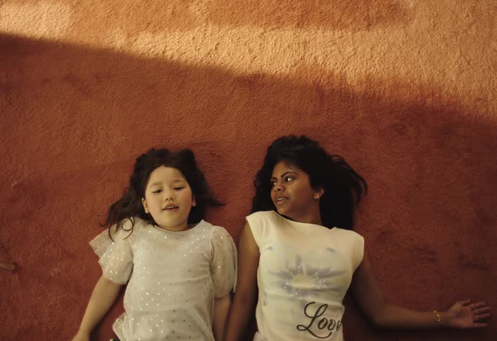 Two children lay down on the carpet