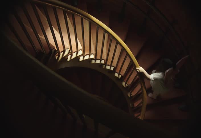 Two children running up the stairs of a house