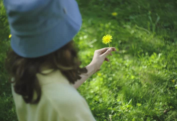 Girl picking a yellow flower