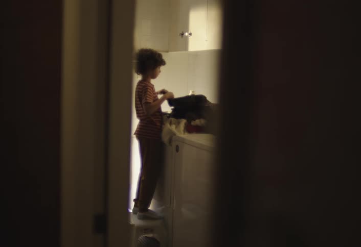Boy taking clothes out of the washing machine