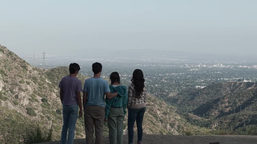 A family is standing on the cliff of the mountain