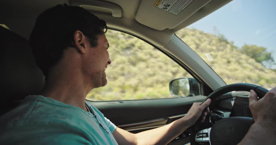 Smiling man driving and talking