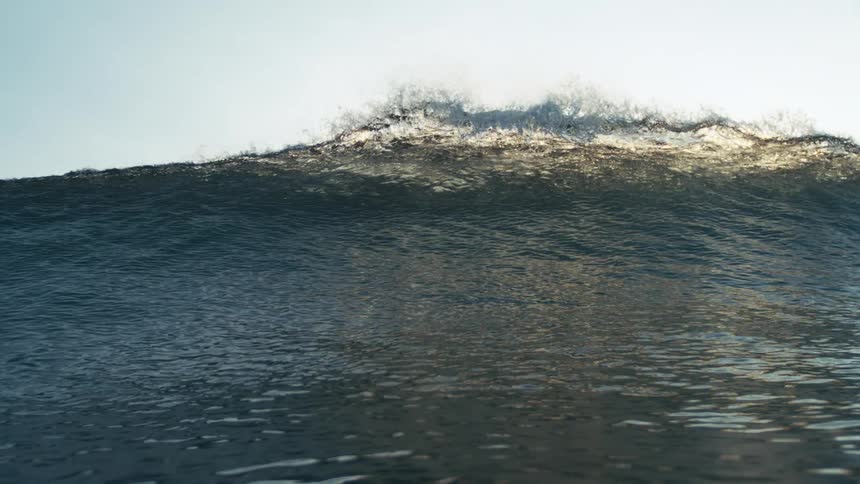 Huge ocean wave forms across the ocean surface during daytime