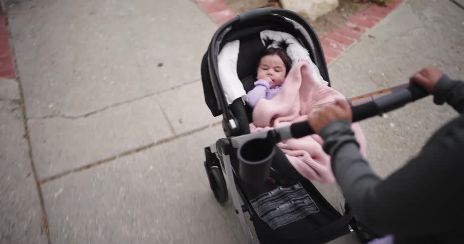 Woman walking carrying a baby in a stroller