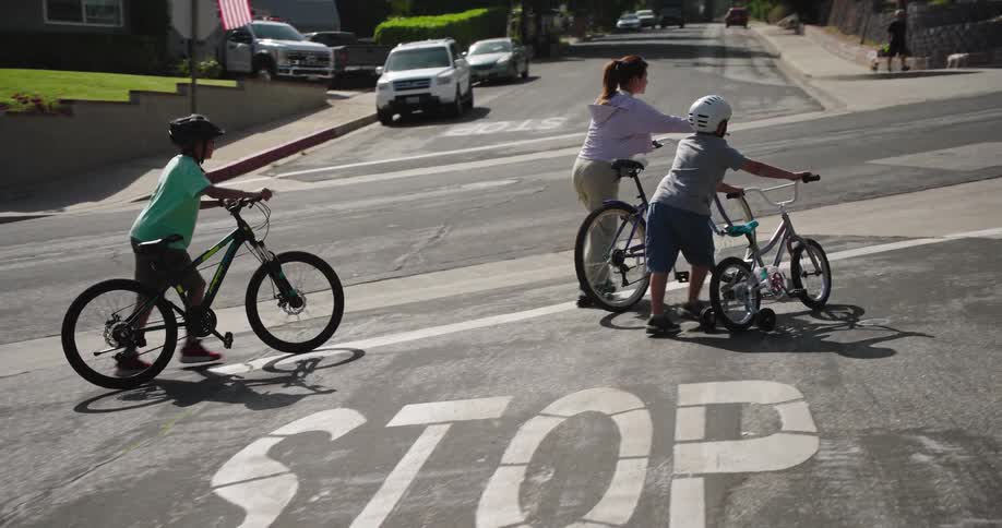 Children walk their bike across the street