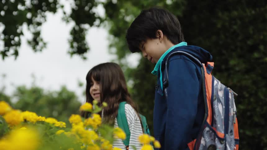 A girl points a stick at a boy
