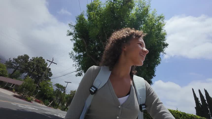 Curly haired girl along with another boy riding a scooter