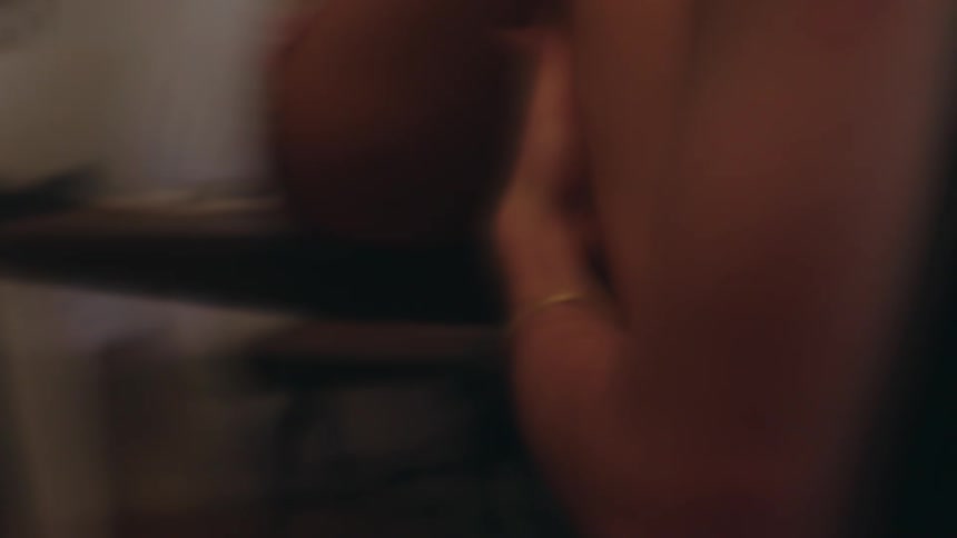 Hands of one person on the legs of another person sitting down