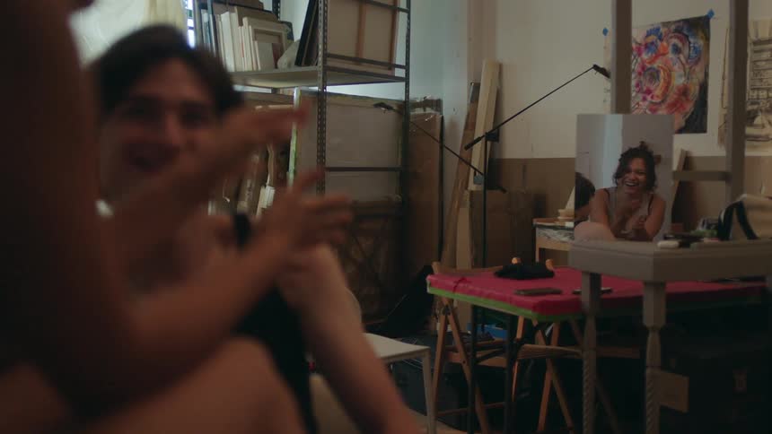 Reflection of a woman in a mirror sitting and interacting with a man