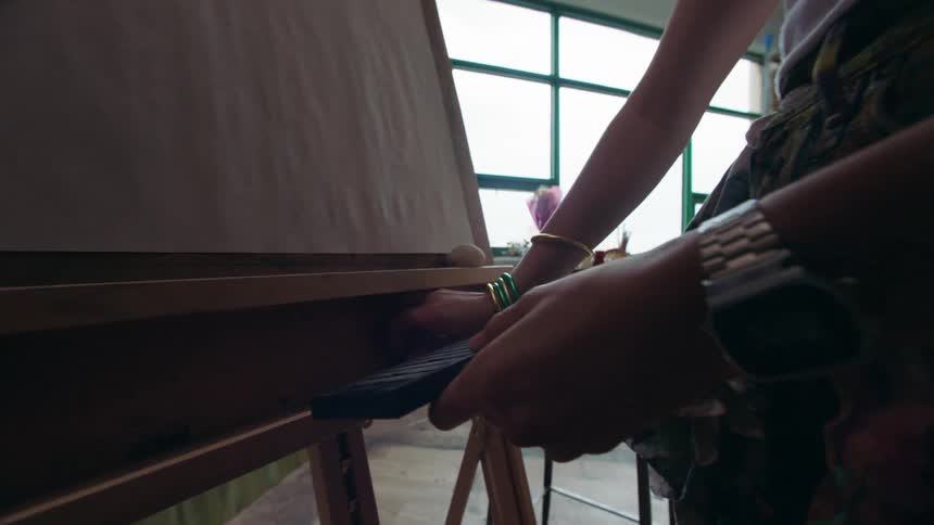 Woman placing a white sheet in a frame