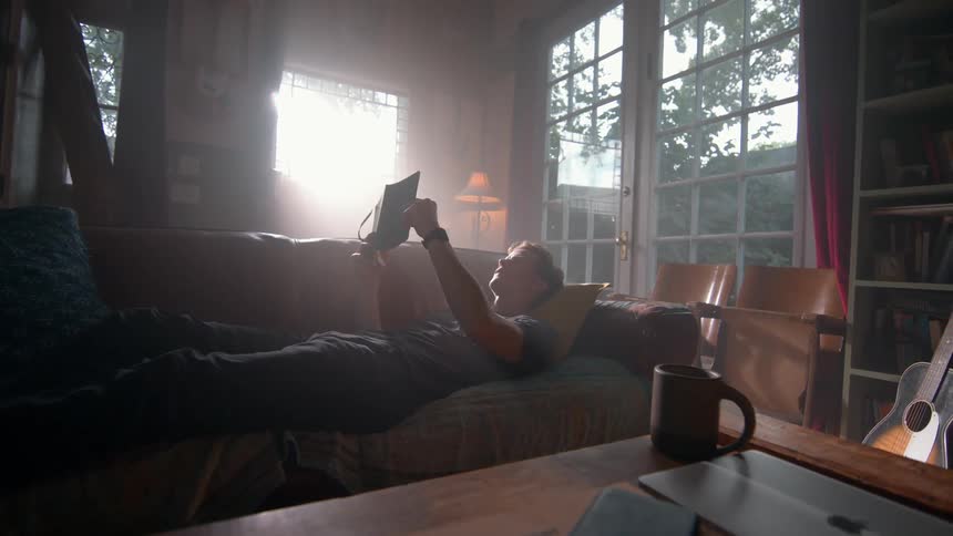 Man lying down looking at a book