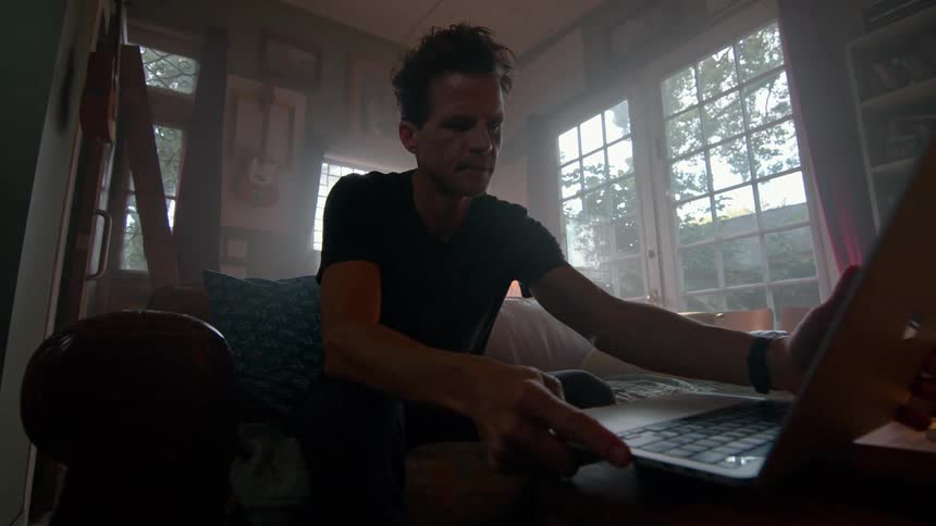 Man sitting on the table opening a laptop