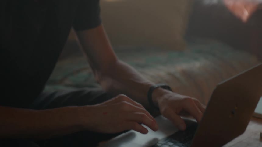 A man is typing on his laptop