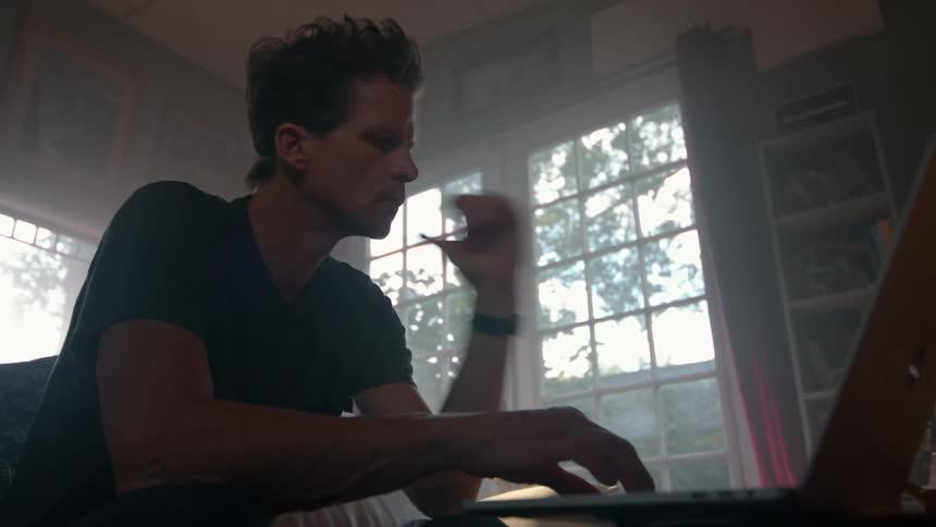 Man sitting interacting with a laptop