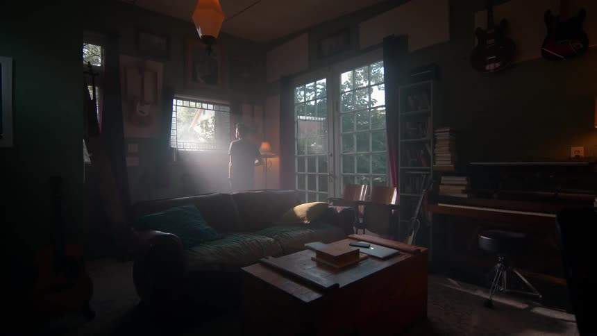 Man walking towards a window with the sun reflecting off it
