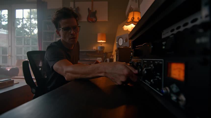 Seated man configuring an electronic device with buttons