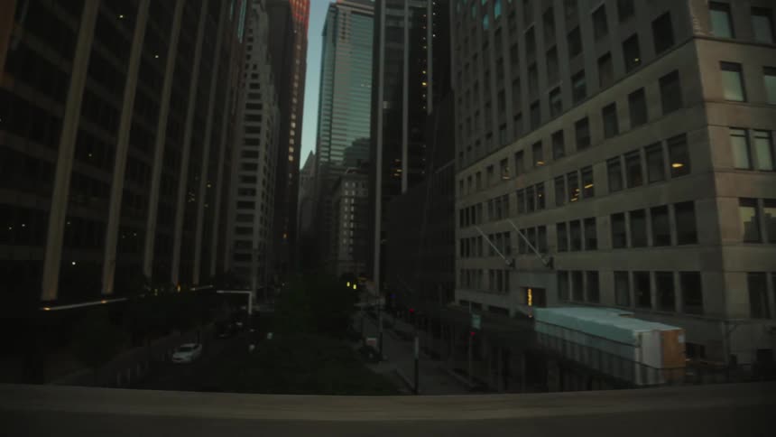 Raised highway passes over a downtown city street after dusk