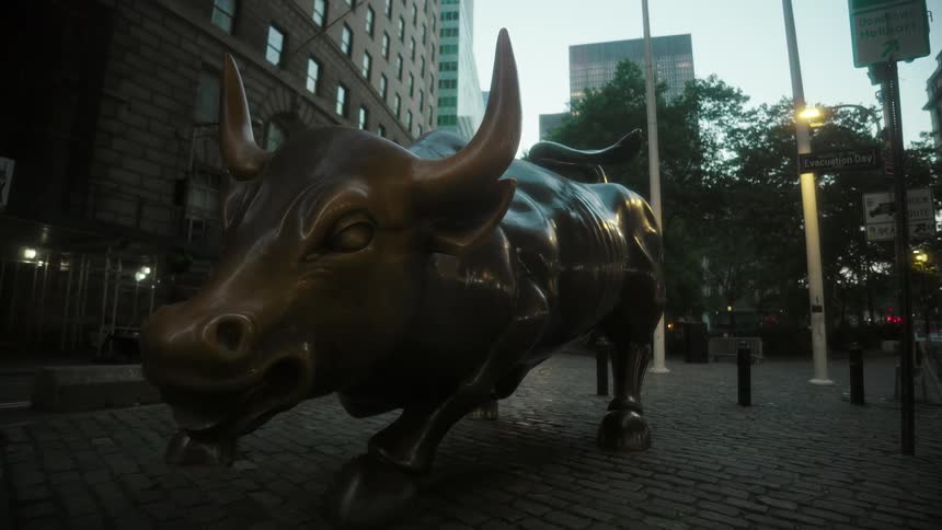 Close up of a bull statue outdoors in a metropolitan city at sunset