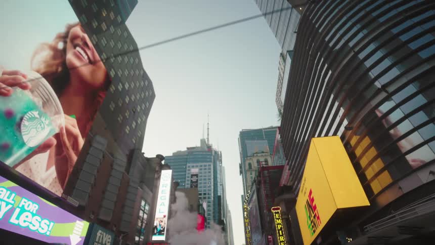 Bright marquees and billboards light up a bustling city street filled with theaters and highrises