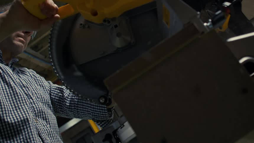 Man performing cutting with an industrial saw machine