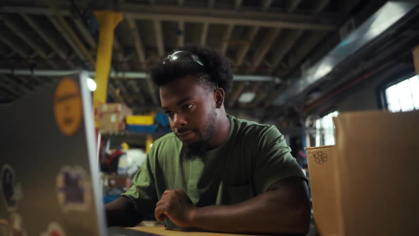 Man sitting interacting with a laptop and checking boxes