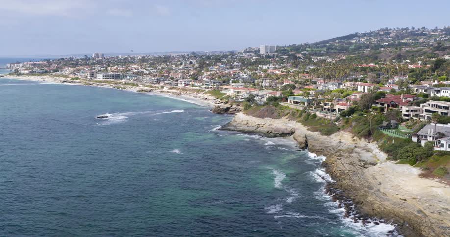 The waves crash against the coast of the city
