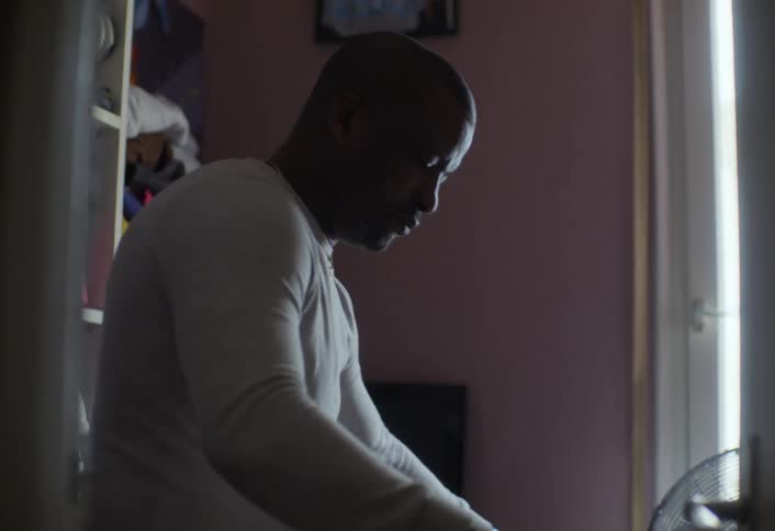 Man in a room of the house ironing clothes