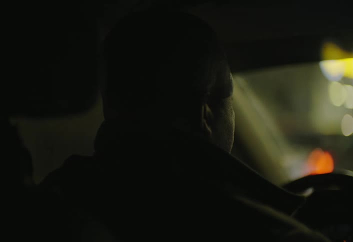 The man turns the steering wheel while driving