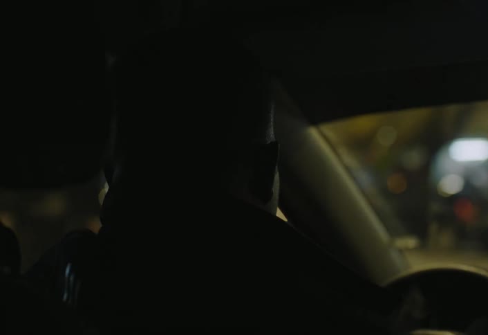 A man is driving at night