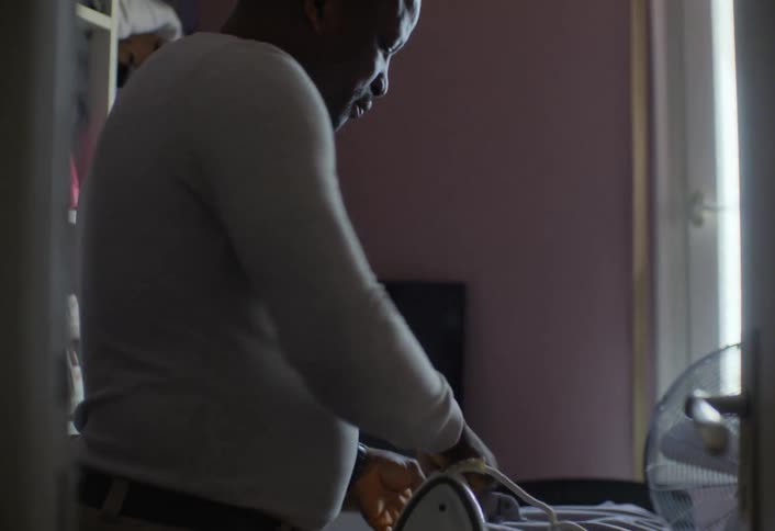 Man ironing a button down shirt on an ironing board