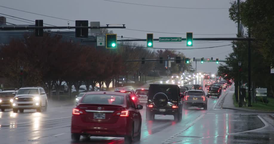 Cars driving through an intersection in the rain