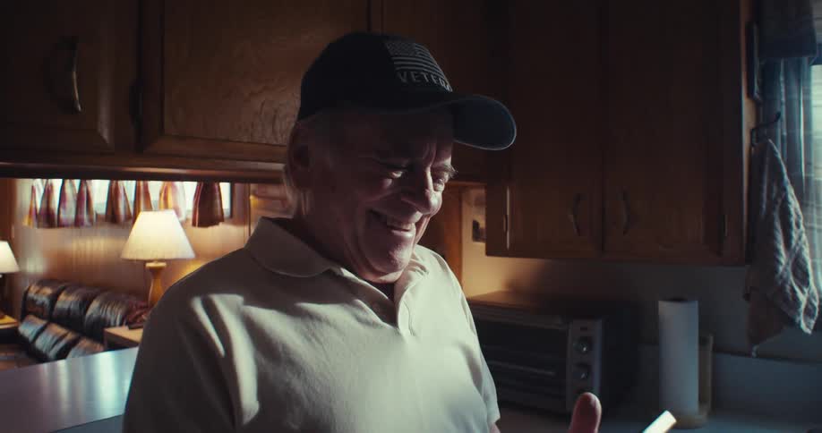 Elderly man laughing while interacting with a smartphone