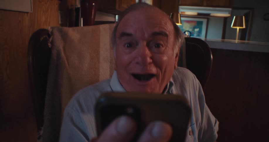 Elderly man happily vibrating with a smartphone