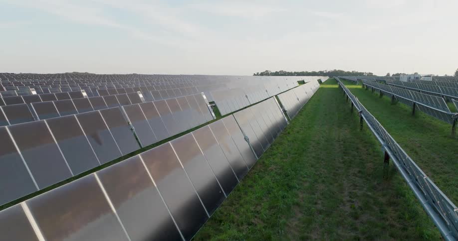 Subtle twist flying low over reflective solar panels extending into the distance