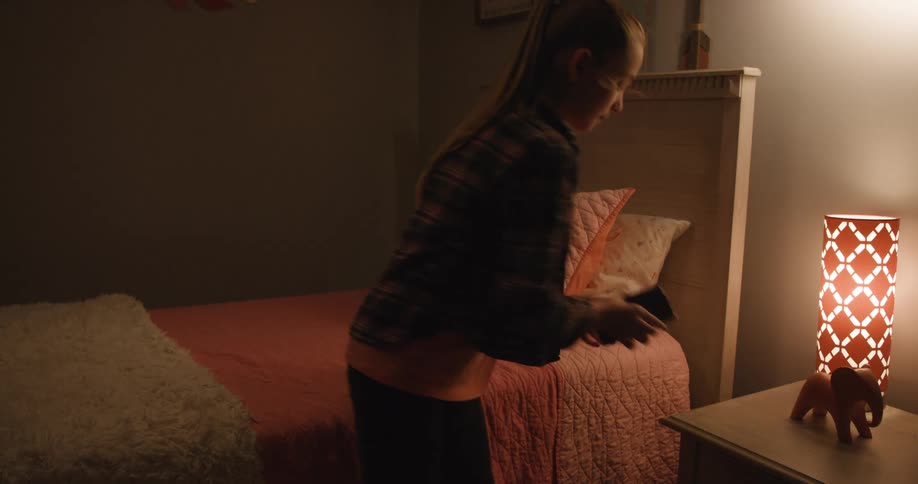 A girl enters a cozy bedroom and picks up her phone to read a text