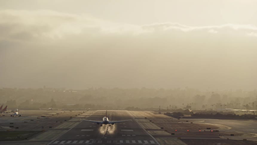 Airplane landing on runway at sunset