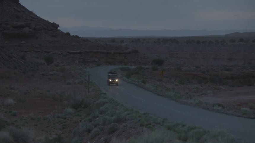 A car driving down a road at dusk