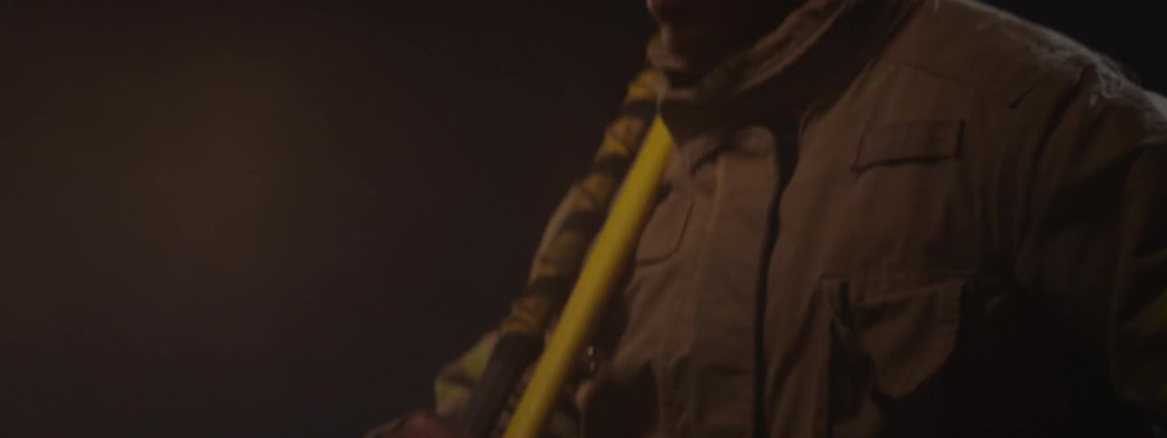 Man in coat holding tools in lowlight space