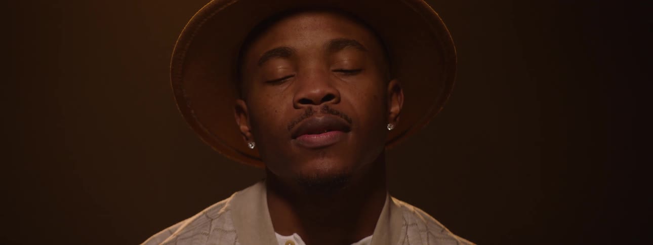 The man wearing a large hat looks up