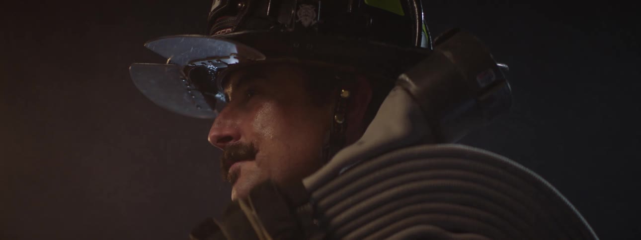 The firefighter is holding a firehose