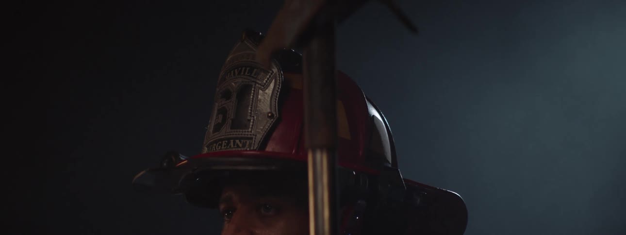 Firefighter in helmet holding a tool