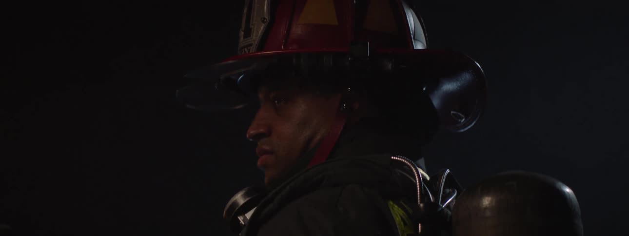 Firefighter in a lowlight space holding tools